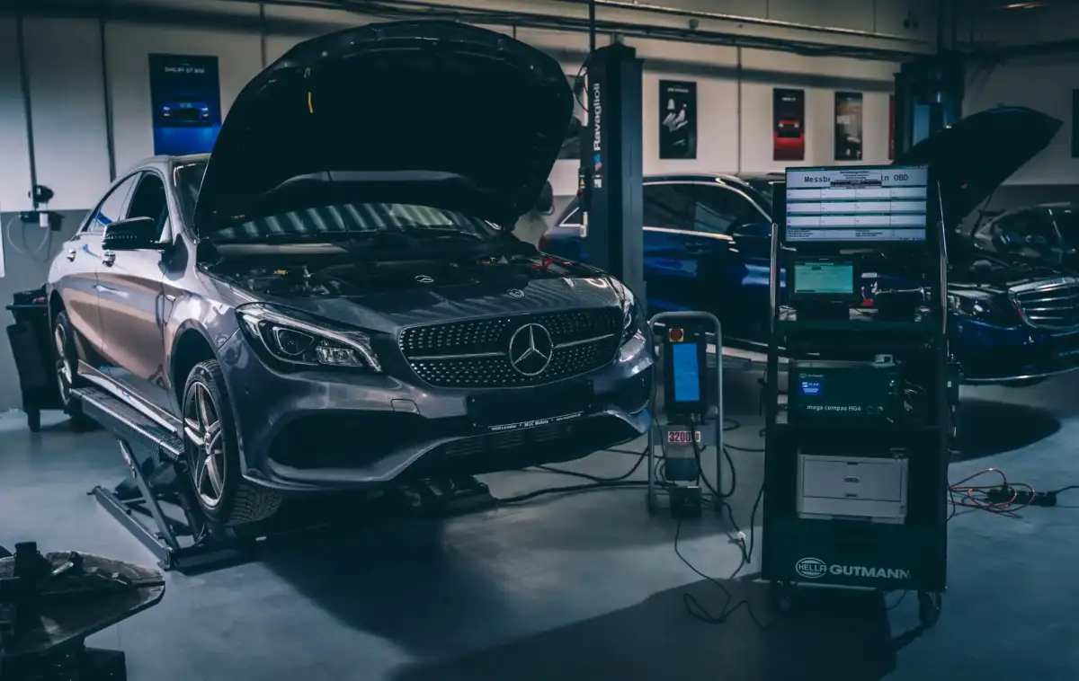 Mercedes-Benz auf der Hebebühne, angeschlossen an ein Diagnosegerät in der MUC Motors Werkstatt