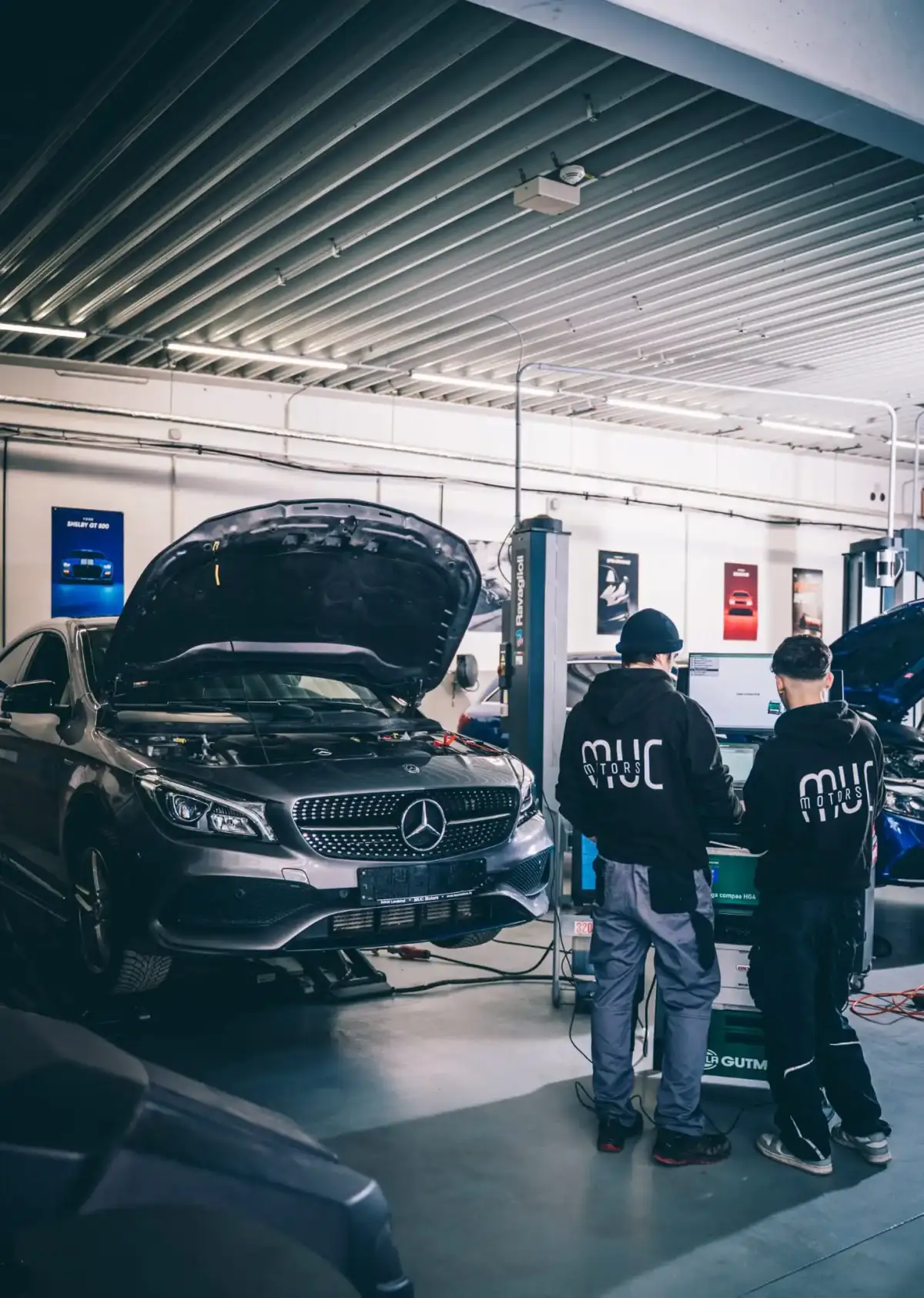 Zwei Mechaniker von MUC Motors reparieren einen Mercedes-Benz in der Werkstatt Landshut